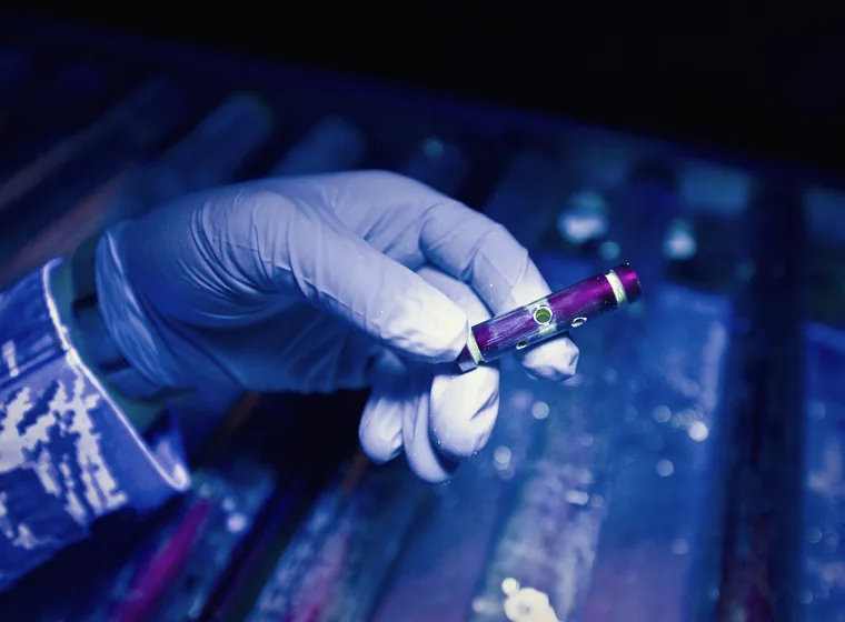 Indicaciones fluorescentes reveladas por partículas magnéticas sobre una pieza de acero